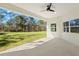 Spacious covered patio with ceiling fan overlooking the lush green backyard at 16431 Penn State Rd, Weeki Wachee, FL 34614