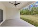 This covered patio features a ceiling fan and a view of the lush backyard at 16431 Penn State Rd, Weeki Wachee, FL 34614