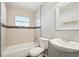 The bathroom offers a tiled bathtub and shower combination, sink, toilet, and a mirror at 1720 W Arch St, Tampa, FL 33607