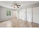 A bedroom has a ceiling fan, wood-style floors, closet, a window, and a doorway to the hallway at 1720 W Arch St, Tampa, FL 33607