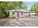 Cozy single-story home with a carport, new paint, and a welcoming red door at 1720 W Arch St, Tampa, FL 33607
