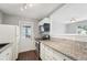A kitchen features granite countertops, wood floors, and a white refrigerator, microwave, and cabinets at 1720 W Arch St, Tampa, FL 33607