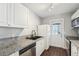 The kitchen features granite countertops, wood floors, and stainless steel appliances with a black sink at 1720 W Arch St, Tampa, FL 33607
