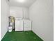 Utility space featuring a washer, dryer, and hot water heater on astroturf flooring at 1720 W Arch St, Tampa, FL 33607