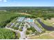 The aerial view features a community clubhouse, pool, tennis courts, and a parking lot surrounded by lush landscaping at 19112 Cypress Green Dr, Lutz, FL 33558