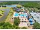 An aerial view displays a luxurious pool, clubhouse, playground and tennis courts near a beautiful lake and golf course at 19112 Cypress Green Dr, Lutz, FL 33558