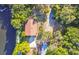 Aerial view of lakefront home surrounded by lush greenery, featuring a private dock and long driveway at 201 Gornto Lake Rd, Brandon, FL 33510