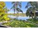 Lush backyard featuring a hammock, chairs, palm trees, and a tranquil lake view at 201 Gornto Lake Rd, Brandon, FL 33510