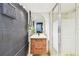 Modern bathroom features a wooden vanity, hanging plant, stylish mirror, and walk-in shower at 201 Gornto Lake Rd, Brandon, FL 33510