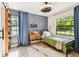 Bright bedroom featuring wood-look tile floors, light gray walls, and a large window at 201 Gornto Lake Rd, Brandon, FL 33510