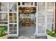 Enclosed dining area with stone floor, wood dining set, decorative chandeliers and walls of windows with flowing white curtains at 201 Gornto Lake Rd, Brandon, FL 33510