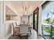 Bright dining room with modern light fixture, table with six chairs, and lake view at 201 Gornto Lake Rd, Brandon, FL 33510