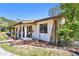 Charming home exterior with a welcoming front porch, stone accents, and landscaped garden beds at 201 Gornto Lake Rd, Brandon, FL 33510