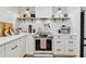 Modern kitchen equipped with white cabinetry, stainless steel appliances, and stylish floating shelves at 201 Gornto Lake Rd, Brandon, FL 33510