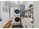 Chic laundry room with stacked washer and dryer, custom wallpaper, butcher block countertop and deep utility sink at 201 Gornto Lake Rd, Brandon, FL 33510