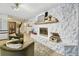 Stone fireplace adds charm, complemented by green armchairs and vintage decor at 201 Gornto Lake Rd, Brandon, FL 33510