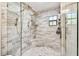 New bathroom showcasing large walk-in shower, dual showerheads and a built-in bench and marble style tile at 201 Gornto Lake Rd, Brandon, FL 33510