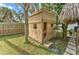 Wooden playhouse in a backyard setting, complete with windows, a door, and a mini-hammock inside at 208 44Th Ne Ave, St Petersburg, FL 33703