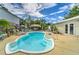 Sparkling backyard pool surrounded by lounge chairs, lush greenery, and a charming tiki bar for ultimate relaxation at 208 44Th Ne Ave, St Petersburg, FL 33703