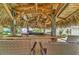 Outdoor tiki bar features a cozy space for entertaining in a tropical setting, complete with seating and a thatched roof at 208 44Th Ne Ave, St Petersburg, FL 33703