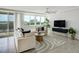 Bright living room with a ceiling fan, a comfortable sofa, and a large window at 223 Island Way # 5D, Clearwater Beach, FL 33767