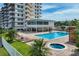 A beautiful pool and hot tub, with palm trees and lounge chairs next to a condo building at 223 Island Way # 5D, Clearwater Beach, FL 33767