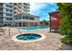 Relaxing pool and spa with lounge seating, umbrellas, and adjacent to the condo building at 223 Island Way # 5D, Clearwater Beach, FL 33767