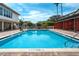Large outdoor pool with clear blue water, seating area, and shade cover, perfect for relaxation at 223 Island Way # 5D, Clearwater Beach, FL 33767