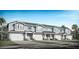 Charming townhome row featuring light blue siding, white trim, two-car garages, and stylish architectural details at 2525 Mario Way, Clearwater, FL 33761