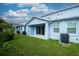 Private backyard with lush green lawn, enclosed by a white fence and mature trees at 2529 Mario Way, Clearwater, FL 33761