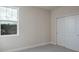 Carpeted bedroom with white closet doors and window at 2529 Mario Way, Clearwater, FL 33761
