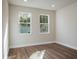 Bright bedroom with hardwood floor and two windows at 2529 Mario Way, Clearwater, FL 33761