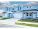 Lovely blue townhouses featuring attached garages, subtle stone work, and pristine grassy areas at 2529 Mario Way, Clearwater, FL 33761