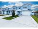 A line of blue townhouses boasts attached garages, stone accents, and freshly cut grass at 2529 Mario Way, Clearwater, FL 33761