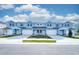 Charming blue townhomes featuring attached garages, stone accents, and manicured landscaping for curb appeal at 2529 Mario Way, Clearwater, FL 33761