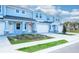 Row of blue townhouses with garages, stone accents, and maintained greenery, adding to its inviting facade at 2529 Mario Way, Clearwater, FL 33761