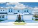 Inviting blue townhomes showing off attached garages, stone accents, and lush lawns for enhanced outdoor appeal at 2529 Mario Way, Clearwater, FL 33761