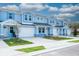 Scenic view of blue townhouses emphasizing garages, stone details, and manicured landscapes at 2529 Mario Way, Clearwater, FL 33761