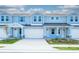 Blue townhomes exhibiting garages, stylish stonework, and neatly trimmed landscaping at 2529 Mario Way, Clearwater, FL 33761