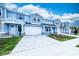 Beautiful blue townhouses each include an attached garage, stone details, and verdant green lawns at 2529 Mario Way, Clearwater, FL 33761
