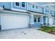 Charming blue townhome featuring a white garage door and brick paved driveway at 2529 Mario Way, Clearwater, FL 33761