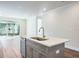 Bright kitchen island features a sink, stainless steel dishwasher and quartz countertop at 2529 Mario Way, Clearwater, FL 33761