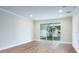 Bright living room with hardwood floor, base molding and sliding glass doors at 2529 Mario Way, Clearwater, FL 33761