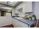 Bright kitchen sink with white cabinets, subway-style backsplash, and a passthrough window to the dining room at 2971 Estancia Blvd # 328, Clearwater, FL 33761