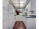 Compact kitchen features all-white appliances, cabinets, and a pass-through window to the dining area at 2971 Estancia Blvd # 328, Clearwater, FL 33761