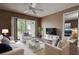 Inviting living room featuring a ceiling fan, sliding glass doors to balcony, and elegant white furnishings at 2971 Estancia Blvd # 328, Clearwater, FL 33761