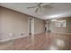 Empty living room with hardwood floors, ceiling fan, and bright light; open to dining area at 2971 Estancia Blvd # 328, Clearwater, FL 33761