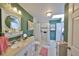 Bright bathroom boasts a white vanity, tiled shower with a curtain, and a laundry closet at 3042 57Th N Ave, St Petersburg, FL 33714