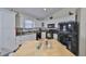 A view of the kitchen featuring white cabinetry, black appliances, and granite counters at 3042 57Th N Ave, St Petersburg, FL 33714
