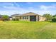 Well-maintained home exterior with screened patio overlooking a spacious, beautifully landscaped backyard at 3204 Mapleridge Dr, Lutz, FL 33558